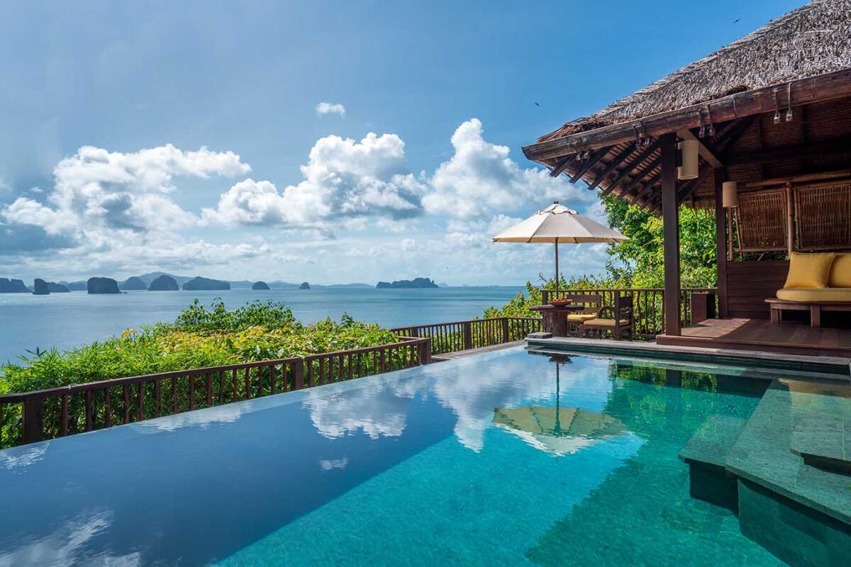 Tropical resort deck featuring an infinity pool and a spectacular view of the Andaman Sea and distant karsts